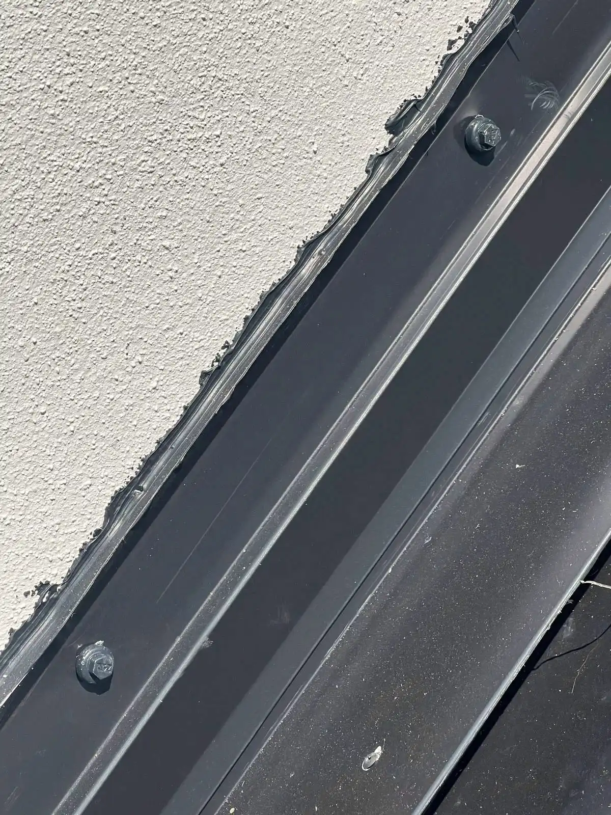 Metal flashing sealed where a roof meets a stucco wall